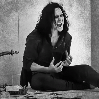 A Black And White Photo Of A Man With Long Hair Sitting On The Floor Screaming GIF