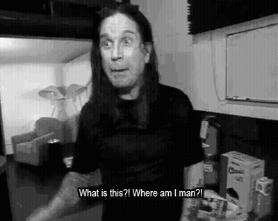 A Black And White Photo Of A Man With Long Hair Standing In A Room And Talking . GIF