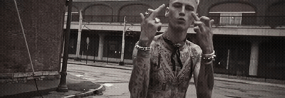A Black And White Photo Of A Man With Tattoos Giving The Middle Finger . GIF
