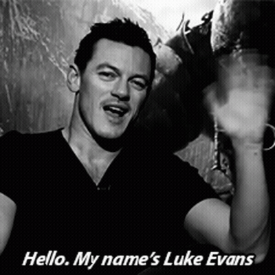 A Black And White Photo Of A Man With The Words Hello My Name 'S Luke Evans Below Him GIF