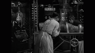 A Black And White Photo Of A Man With The Words It 'S Alive Behind Him GIF