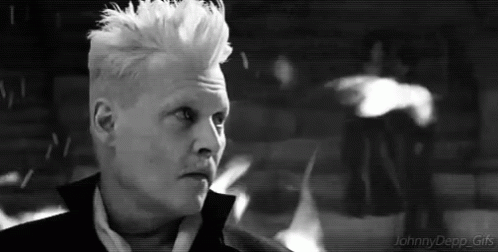 A Black And White Photo Of A Man With White Hair In A Suit . GIF