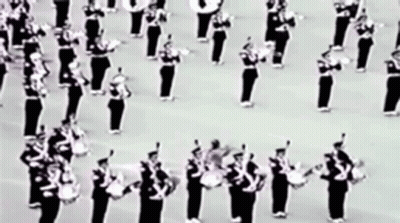 A Black And White Photo Of A Marching Band Playing Drums GIF