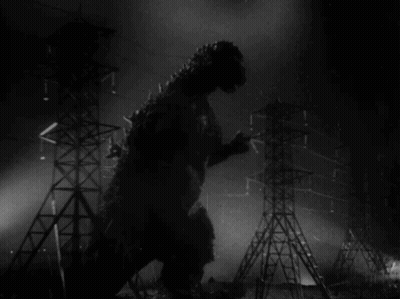 A Black And White Photo Of A Monster Standing In Front Of A Bunch Of Power Lines GIF