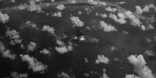 A Black And White Photo Of A Nuclear Explosion In The Clouds . GIF