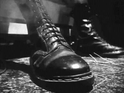 A Black And White Photo Of A Pair Of Boots GIF