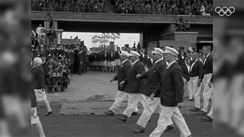 A Black And White Photo Of A Parade With The Olympics Logo On The Bottom GIF