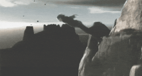 A Black And White Photo Of A Person Climbing Up A Mountain GIF
