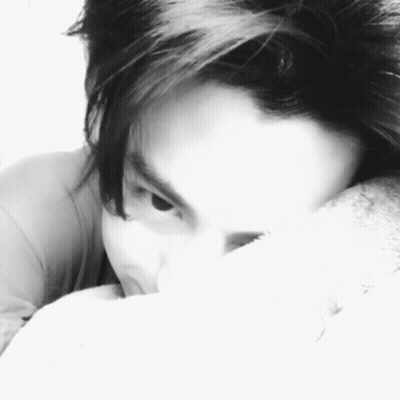 A Black And White Photo Of A Person Covering Their Face With A Pillow GIF