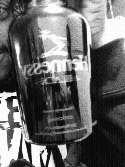A Black And White Photo Of A Person Holding A Bottle Of Hennessy GIF