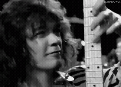 A Black And White Photo Of A Person Holding A Guitar . GIF