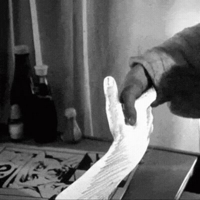 A Black And White Photo Of A Person Holding A Piece Of Paper GIF