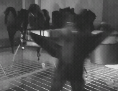 A Black And White Photo Of A Person Holding A Sword GIF
