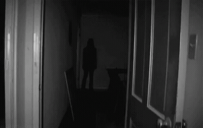 A Black And White Photo Of A Person In A Dark Room GIF