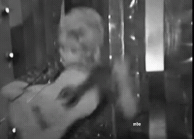 A Black And White Photo Of A Person Laying On A Bed In Front Of A Mirror . GIF