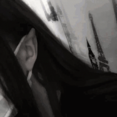 A Black And White Photo Of A Person Looking Out A Window With The Eiffel Tower In The Background GIF