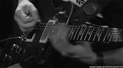 A Black And White Photo Of A Person Playing A Guitar With A Strap That Says Inventive GIF