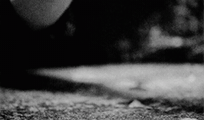 A Black And White Photo Of A Person 'S Feet On A Concrete Surface . GIF