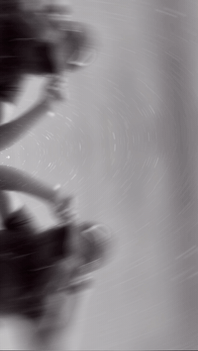 A Black And White Photo Of A Person Spinning A Steering Wheel GIF