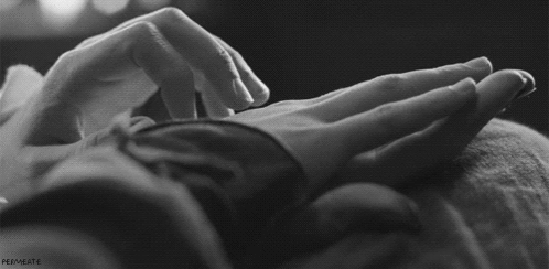 A Black And White Photo Of A Person Touching Another Person 'S Hand . GIF