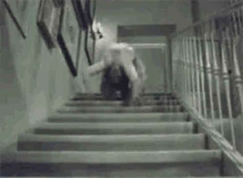 A Black And White Photo Of A Person Walking Up Stairs . GIF