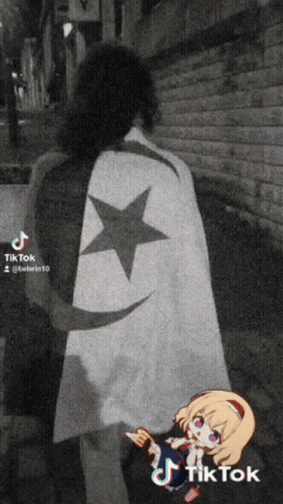 A Black And White Photo Of A Person Wearing A Cape With A Black Star On It GIF