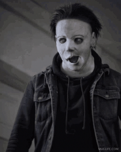 A Black And White Photo Of A Person Wearing A Mask And A Jacket GIF