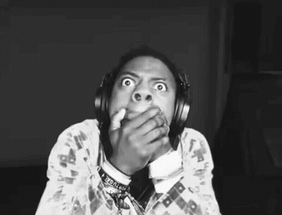 A Black And White Photo Of A Person Wearing Headphones And Covering Their Mouth . GIF