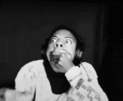 A Black And White Photo Of A Person Wearing Headphones Making A Funny Face . GIF