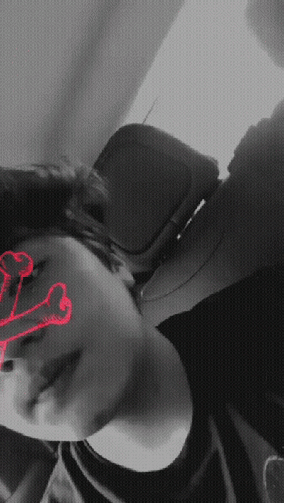 A Black And White Photo Of A Person With A Red Skull In The Background GIF