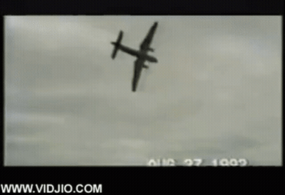A Black And White Photo Of A Plane Flying Through The Air . GIF