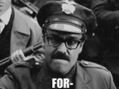 A Black And White Photo Of A Police Officer Holding A Gun And The Words For Written On His Face GIF