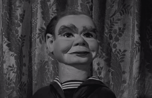 A Black And White Photo Of A Puppet With A Striped Shirt GIF