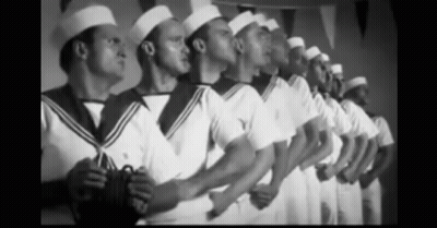 A Black And White Photo Of A Row Of Men In Sailor Uniforms GIF