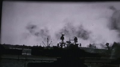 A Black And White Photo Of A Ship In The Water With Smoke Coming Out Of It GIF