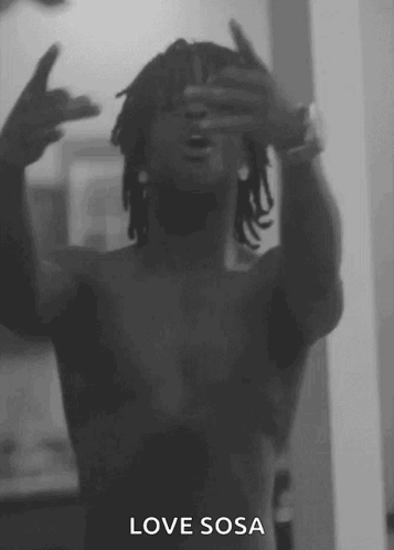 A Black And White Photo Of A Shirtless Man Making A Peace Sign GIF