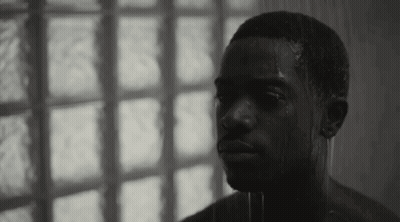 A Black And White Photo Of A Shirtless Man Taking A Shower In Front Of A Window . GIF