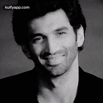 A Black And White Photo Of A Smiling Man . GIF