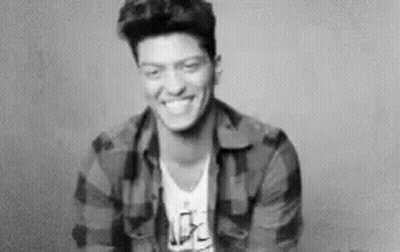 A Black And White Photo Of A Smiling Man In A Plaid Shirt . GIF