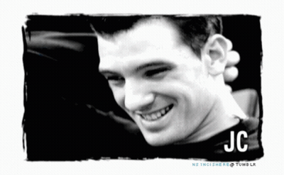 A Black And White Photo Of A Smiling Man With The Name Jc GIF