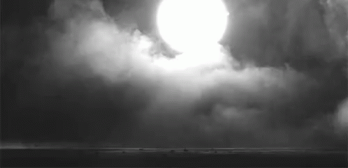 A Black And White Photo Of A Sun Shining Through The Clouds . GIF