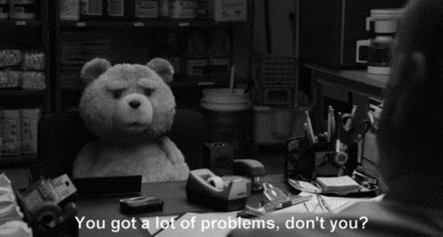 A Black And White Photo Of A Teddy Bear Sitting At A Desk With A Man Talking To It . GIF
