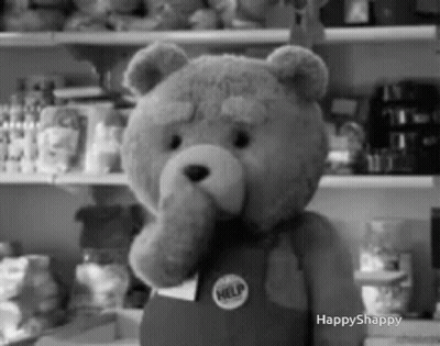 A Black And White Photo Of A Teddy Bear Wearing Overalls And A Help Badge . GIF