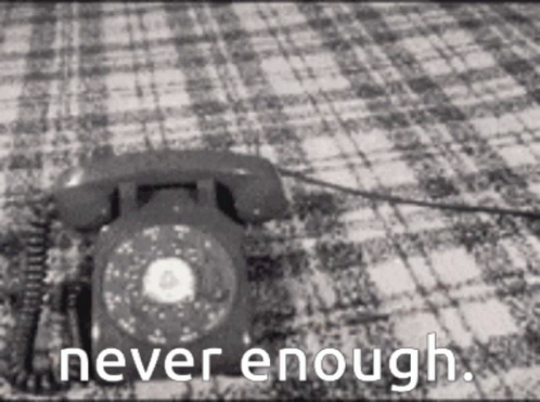 A Black And White Photo Of A Telephone On A Checkered Blanket With The Words Never Enough Written Below It . GIF