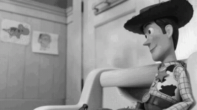A Black And White Photo Of A Toy Story Woody Sitting In A Chair . GIF