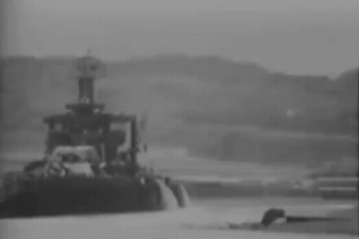 A Black And White Photo Of A Tug Boat In The Water . GIF