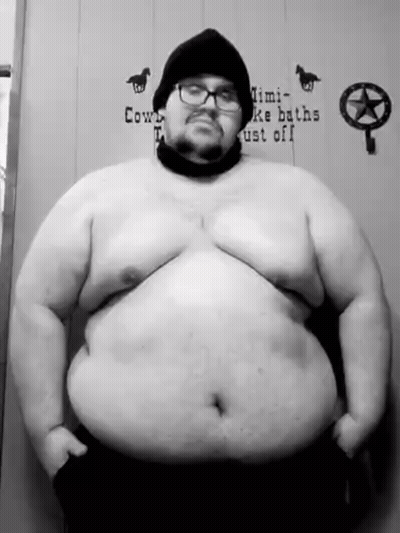 A Black And White Photo Of A Very Fat Man With Glasses And A Beanie . GIF