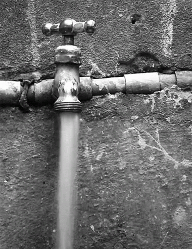 A Black And White Photo Of A Water Faucet With Water Running Out Of It GIF