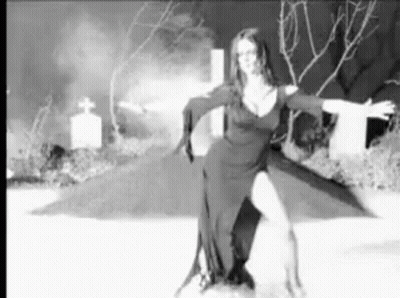A Black And White Photo Of A Woman Dancing In A Cemetery . GIF