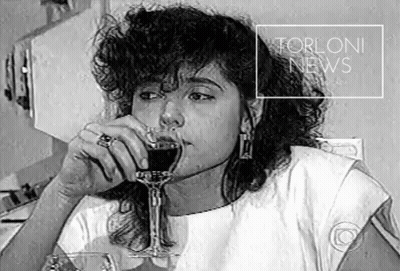 A Black And White Photo Of A Woman Drinking A Glass Of Wine With The Words Torloni News Above Her GIF
